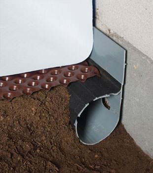 Closeup of a crawl space drainage system installed in Red Hook