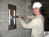 Attempting to straighten a bowed foundation wall by straightening a wall anchor system in a New City home.