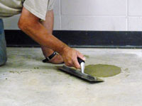 Repairing the cored holes in the concrete slab floor with fresh concrete and cleaning up the New City home.
