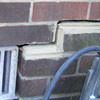 A closeup of a failed tuckpointing job where the brick cracked on a Chester home.