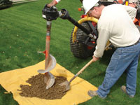 Auguring a hole in the earth for a foundation wall repair system in New City