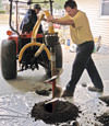 Digging a hole in the garage floor to make room for a wall anchor installation in Stony Point, New York