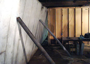 A severely tilting foundation wall propped up by steel beams in Chester.