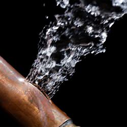 A bursting copper pipe in Spring Valley, with water gushing out.