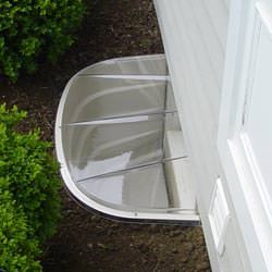 A vinyl basement window and covered window well in Hyde Park