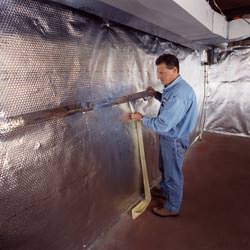 Installation of a radiant heat and vapor barrier on a basement wall in Highland